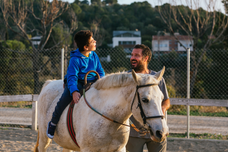 Un niño monta un caballo de terapia